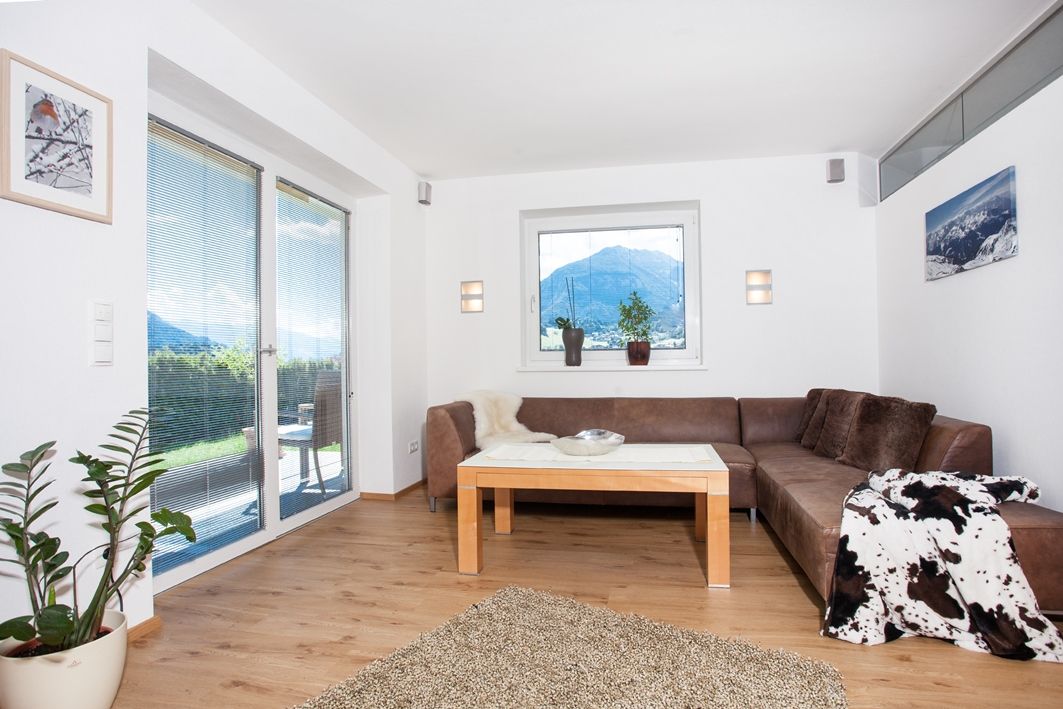 Ein Ferienhaus Wiesing mit Couch und Blick auf die Berge.
