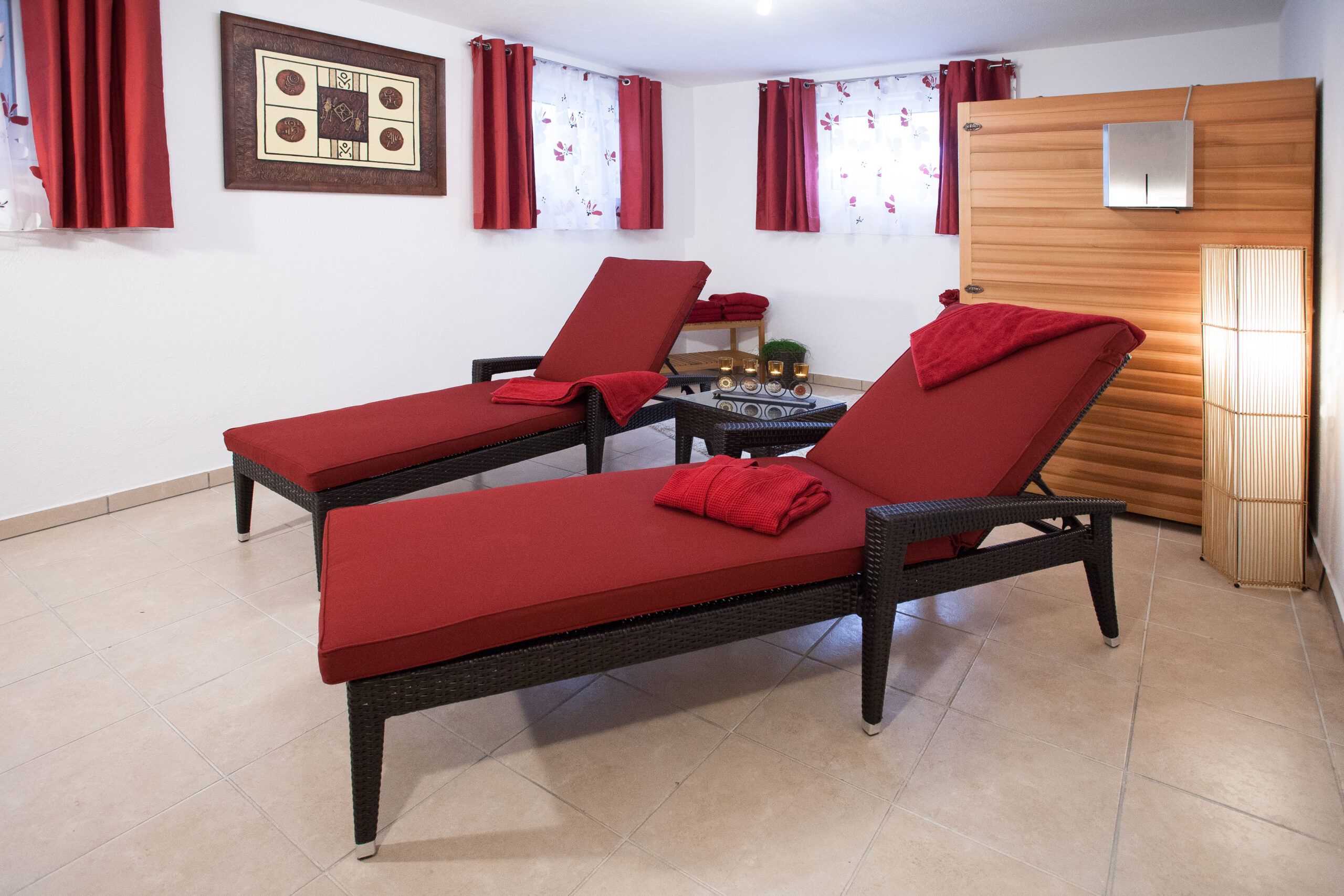 Zwei rote Liegestühle in einem Raum.