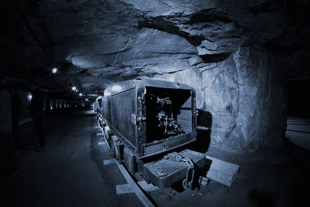 Ein Zug parkt in einer dunklen Silberbergwerk-Höhle.