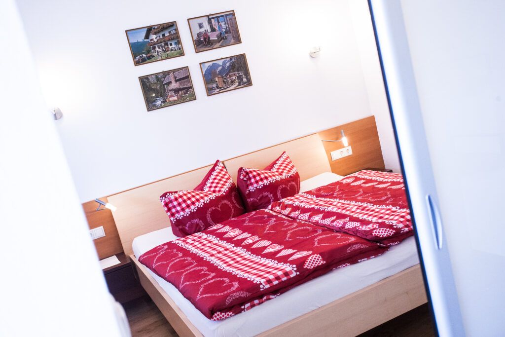 Ein Bett mit einer rot-weißen Bettdecke.